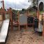 Campanille playground castle se skluzavkou a lezeckými konstrukcemi na písčitém povrchu