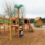 Britta's Playhouse venkovní dřevěná herní konstrukce se skluzavkou, lezeckou sítí a barevným herním domkem v
