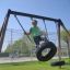 Chlapec se houpe na Double Tyre double swing na hřišti.