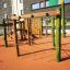 Spillikins wooden playhouse na moderním hřišti s lezeckými lany a dřevěnými konstrukcemi.