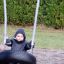 Dítě sedící na Wooden Tire double swing na hřišti.