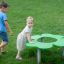 Děti si hrají kolem Clover Play Table v parku.