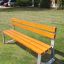 Tallin Bench w/ Backrest v travnaté parkové oblasti.