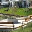 Parková odpočinková zóna s Ryga Bench w/ Backrest a dalšími lavičkami v moderním rezidenčním prostředí