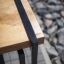 Thor small bench s dřevěným sedákem a černým kovovým rámem poblíž kamenné cesty
