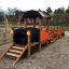 Hřiště Locomotive with cars train playhouse s dřevěnou konstrukcí.