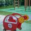 Červená pružinová houpačka Copter rocking na hřišti.