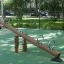 Nature Seesaw na hřišti s dřevěným designem a kovovými madly.