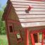 Dřevěný herní domek s červeným lemováním v travnaté oblasti - Anna's Playhouse.