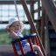 Dítě si užívá jízdu na Baby Single Swing na hřišti.