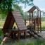 Galapagos wooden playhouse with slide v prostředí parku.