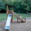 Elbrus wooden playhouse with slide na hřišti obklopeném stromy