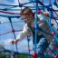 Dítě leze na vybavení hřiště Autan climbing net za slunečného dne