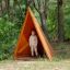Dítě stojící uvnitř Tipi Nature wooden house na hřišti v lesním prostředí