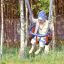 Dítě si užívá Wooden Baby double swing v listnatém hřišti