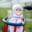 Dítě sedící venku v Wooden Baby double swing