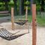Double Hammock ve venkovním parku s dřevěnými sloupky a sítí.