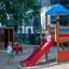 Bird Nest Swing with Tower (BNS 120 cm) single slide v provozu na hřišti, kde si hrají děti.