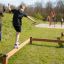 Děti si hrají na vybavení Trim Trail Line v parku.
