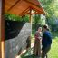 Picnic Shelter w/ Blackboard venkovní dřevěná herní konstrukce s tabulí a interagujícími lidmi
