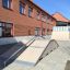 Vysoká skateboardová rampa Quarter-Pipe před cihlovou budovou.