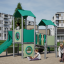 Tower playhouse with a slide na hřišti s dětmi hrajícími si kolem