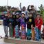 Děti pózují se skateboardy ve skateparku.