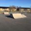 Combination 16 rampy skateparku ve venkovním areálu s budovami v pozadí.