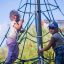 Dvě děti šplhají na Powerclimber climbing net venku.