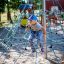 Dítě šplhá na Powerclimber climbing net na hřišti.