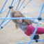 Dívka šplhající na Powerclimber climbing net na hřišti.