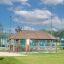 Long Firehouse dřevěný přístřešek na hřišti s lavičkami a piknikovými stoly venku.