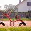 Červené SeeSaw hřišťové vybavení se sedadly a madly na sportovním hřišti