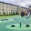 SeeSaw na moderním hřišti se skluzavkami a lezeckými konstrukcemi.