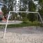 Silver Double Swing na hřišti s pískem a nedalekým parkovým vybavením.