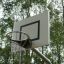 Venkovní basketbalový koš v parku s stromy v pozadí.