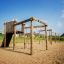 Kampinos wooden playhouse na slunném hřišti.