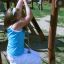 Dívka si hraje na lezeckém laně Kampinos wooden playhouse.
