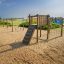 Kampinos wooden playhouse na pískovém venkovním hřišti u moře.
