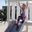 Dívka sjíždí po skluzavce Nature Ship Sandbox, wooden playhouse