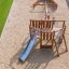 Dřevěný herní domeček Nature Ship Sandbox se skluzavkou na hřišti.