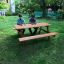 Larchwood Table & Bench v zahradním prostředí se dvěma sedícími osobami.