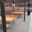 Venkovní Table & Bench umístěný pod pergolou na školním dvoře.