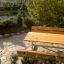 Dřevěný venkovní Table & Bench umístěný v zahradě.