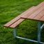 Venkovní dřevěná sada Table & Bench na zelené travnaté ploše.