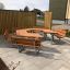 Dřevěný School Table & Bench uspořádaný do šestiúhelníkového tvaru na dlážděné venkovní ploše.