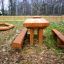 Venkovní dřevěný Table & Bench Nature umístěný na zahradě za domem.