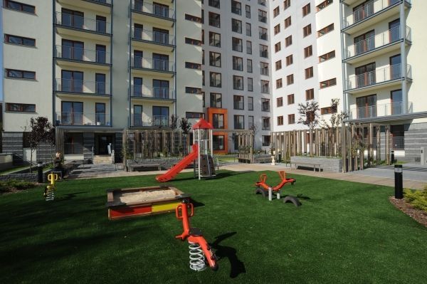 Tlumicí podložka 45 mm s umělou trávou instalovaná na moderním hřišti s různými herními za