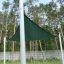 Sun Shade Triangle 3x3x3 Atlantis (Metal) instalovaný na travnaté ploše s vysokými stromy v pozadí