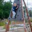 Dítě lezoucí na Tipi II climbing net na hřišti.